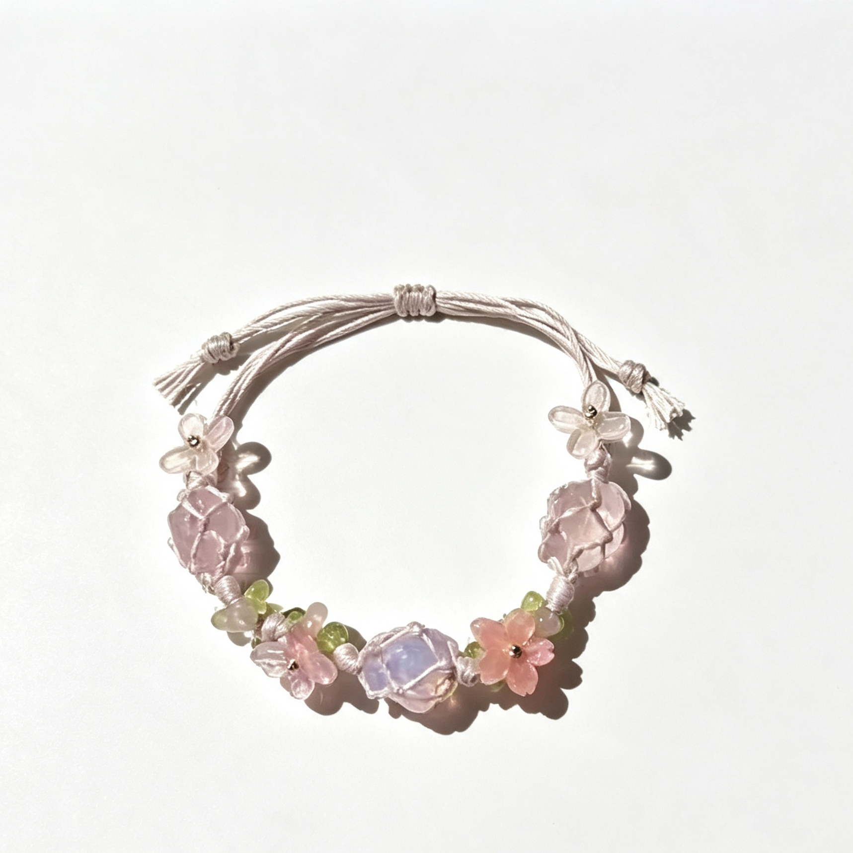 Celestial Insight bracelet with pink, lilac, and green beads on a pale adjustable cord